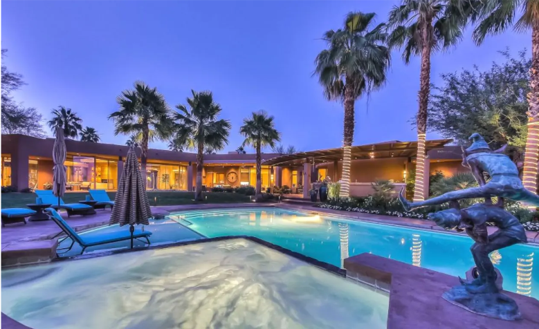 A mesmerizing nighttime view of the pool at Villa Margaux, surrounded by palm trees and luxurious ambiance.