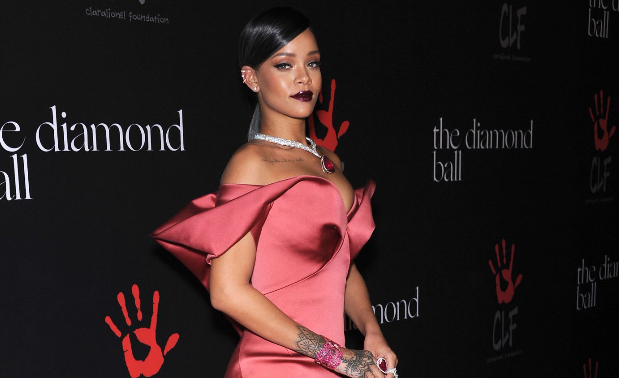 Rihanna in an elegant satin gown at The Diamond Ball, a charity gala for the Clara Lionel Foundation, posing on the red carpet.