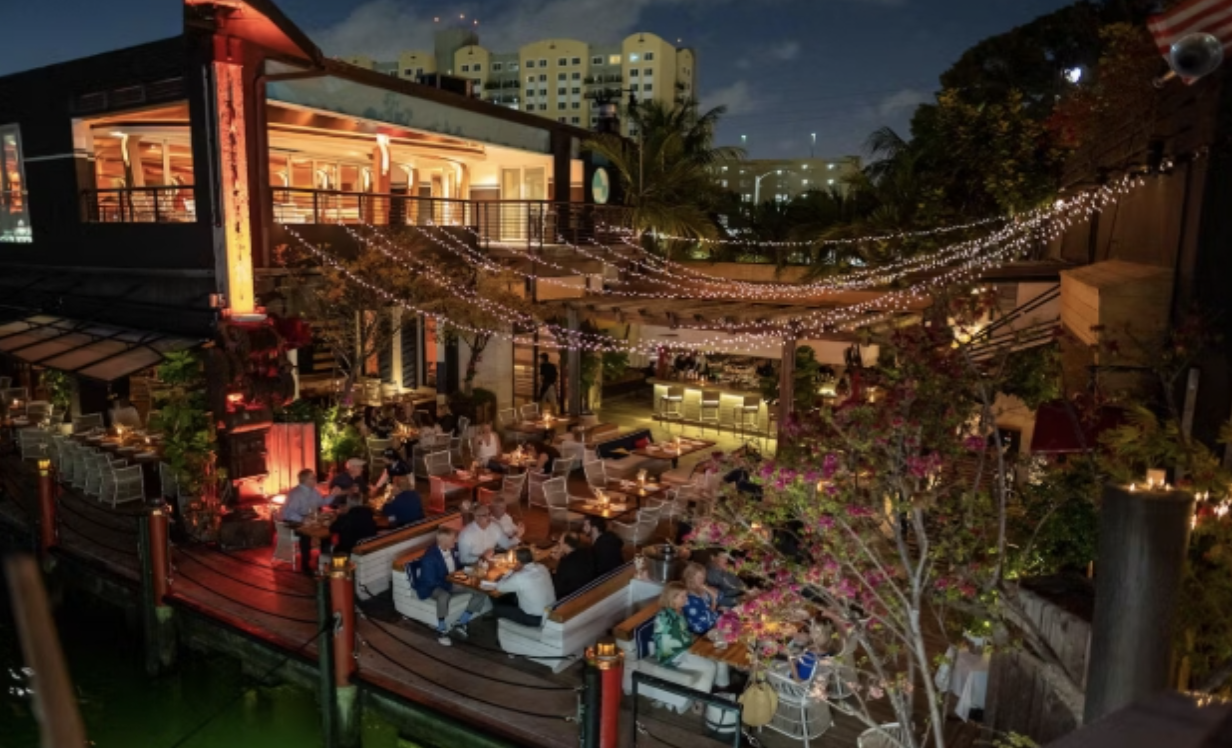 Seaspice Brasserie & Lounge in Miami with waterfront seating, string lights, and boat docking for an upscale dock and dine experience.