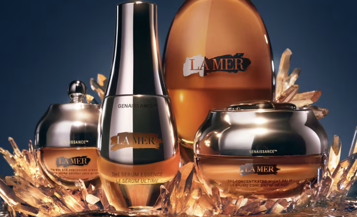 Admire the luminous Genaissance de La Mer skincare collection, situated amidst radiant golden crystals.