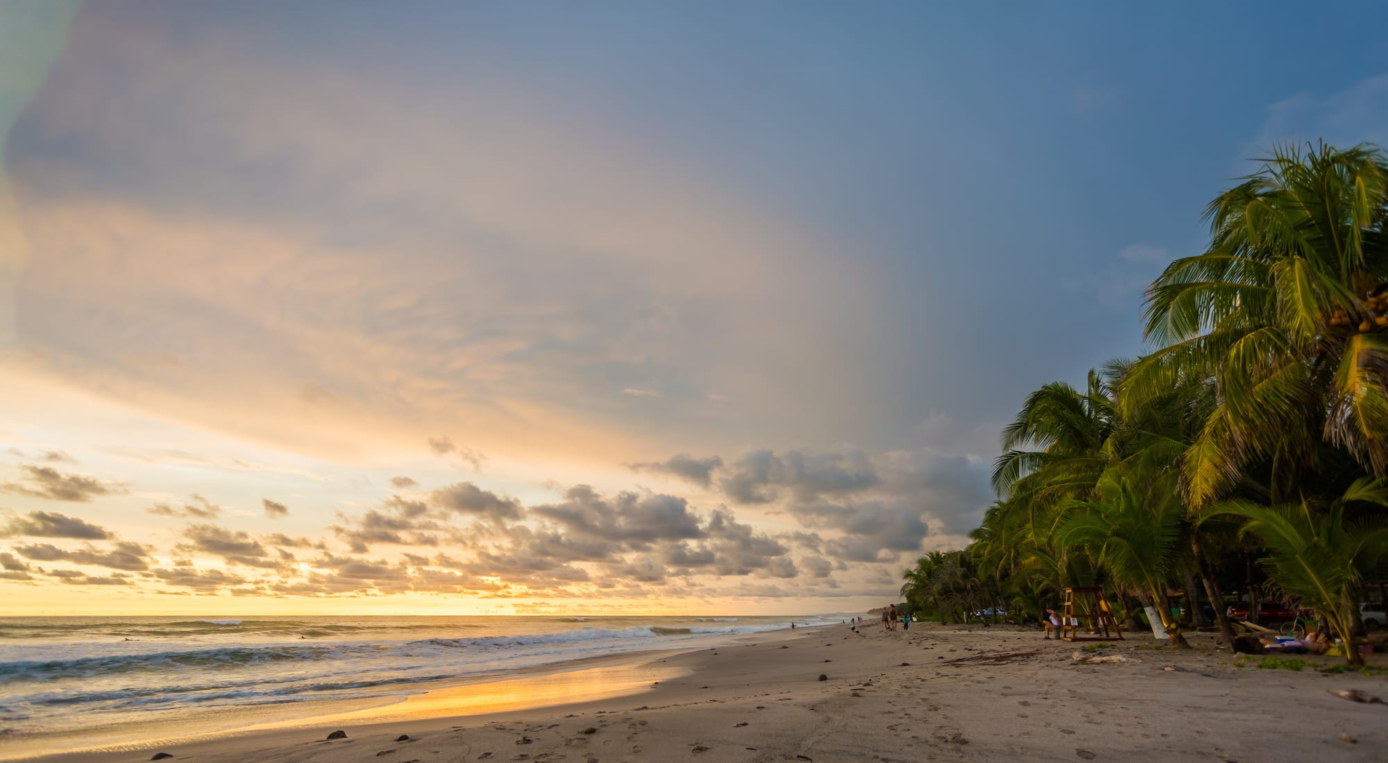 Golden hour at Santa Teresa Beach, where surfers ride the last waves of the day against a backdrop of swaying palms and endless Pacific horizons.